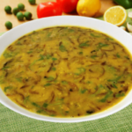 bengali style masoor dal served in a white bowl on a green table cloth