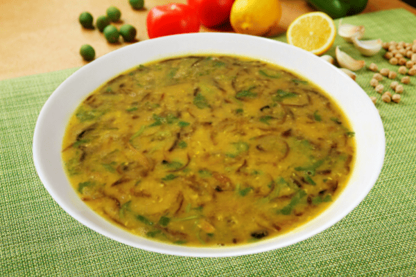 bengali style masoor dal served in a white bowl on a green table cloth