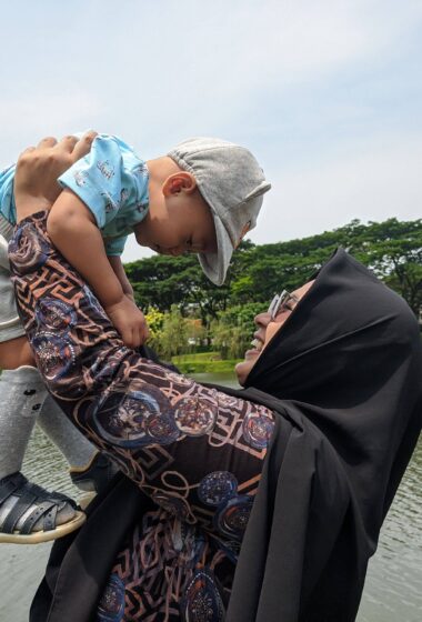 muslim mom holding child high